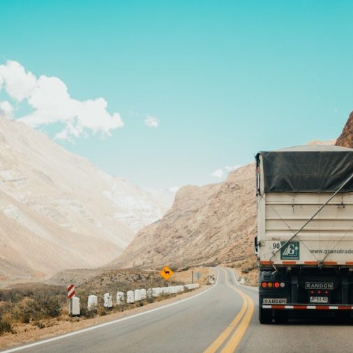 photo of truck driving along moutains